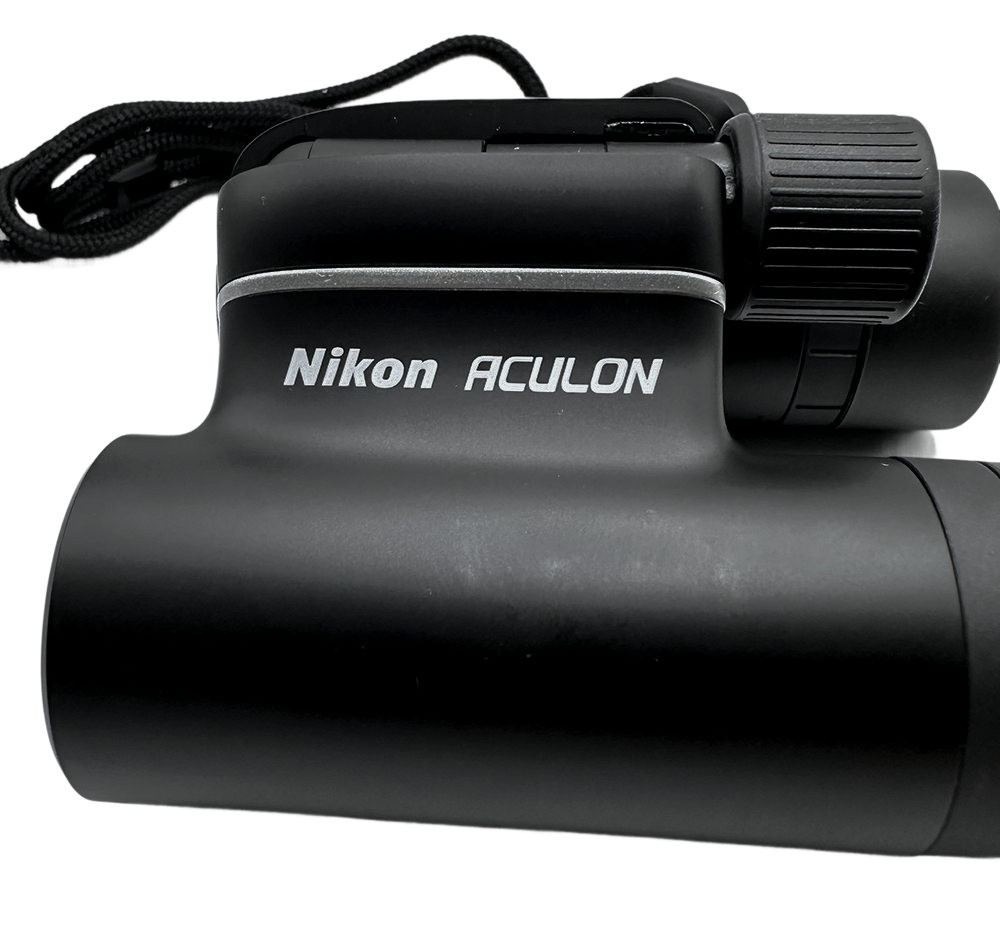 Black Nikon Aculon T01 binoculars with a textured grip and neck strap, displayed on a white background.