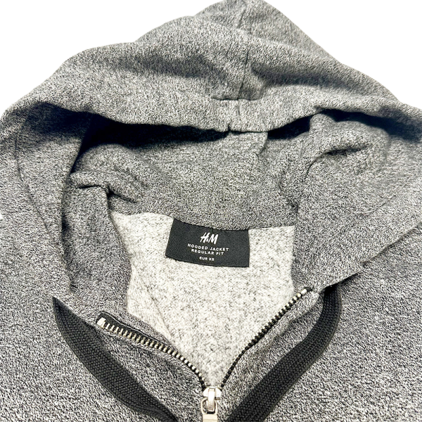 Close-up of a grey H&M Zip-through Hoodie with visible zipper and label on the inside collar.