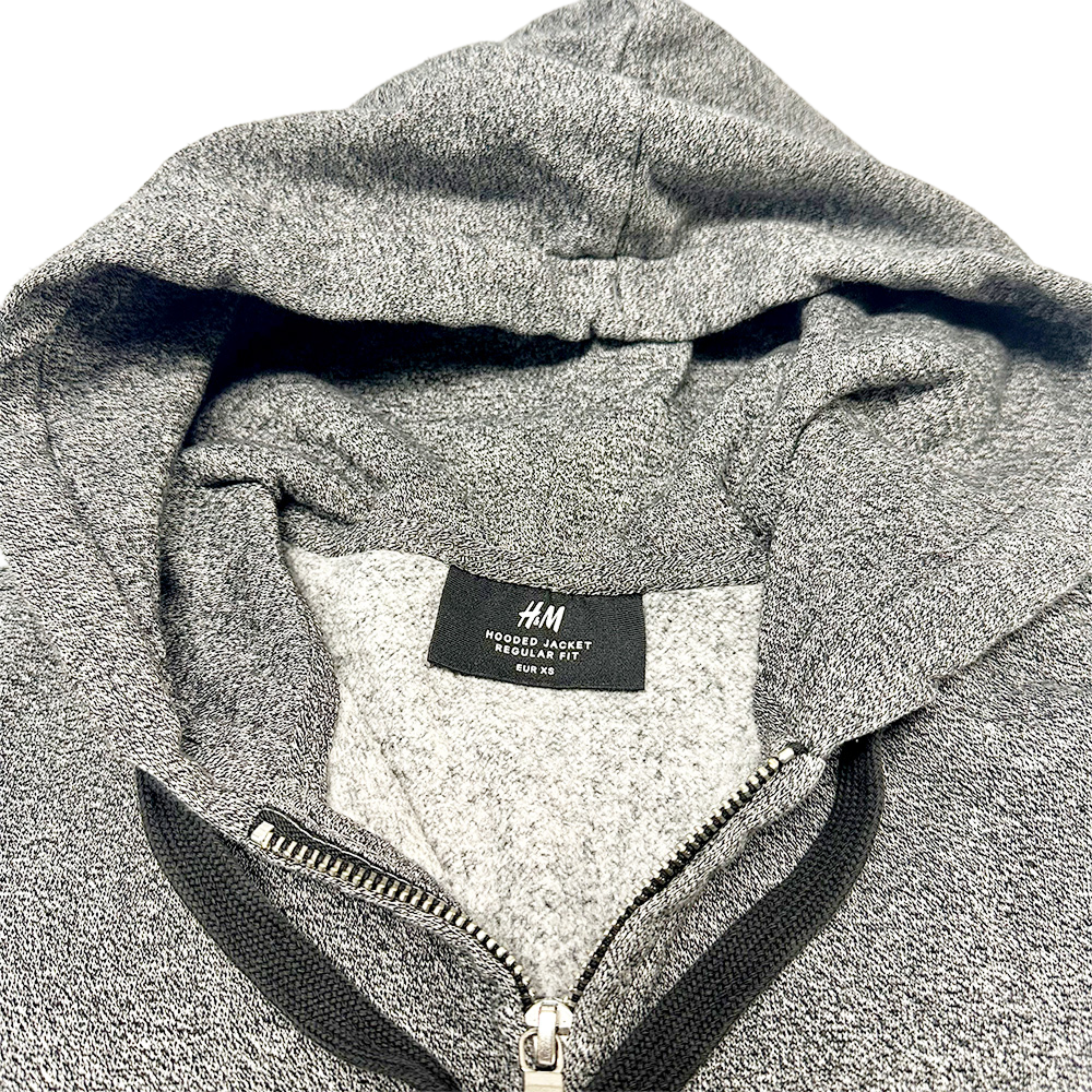 Close-up of a grey H&M Zip-through Hoodie with visible zipper and label on the inside collar.