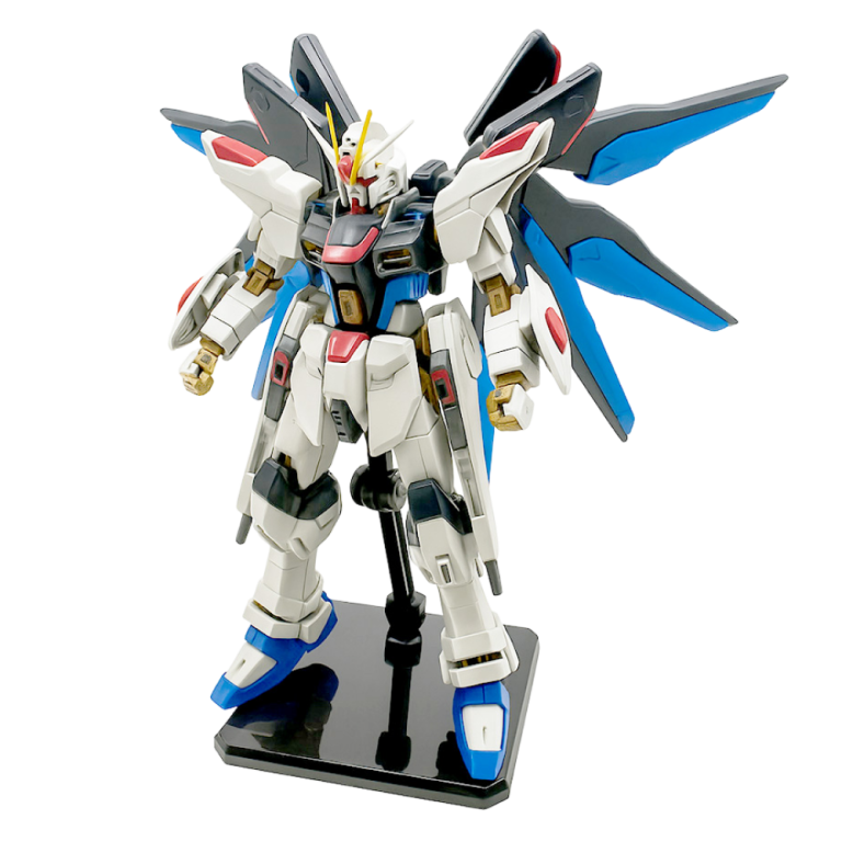 Gundam Strike Freedom Figure with blue wings, standing on a display base against a white background.