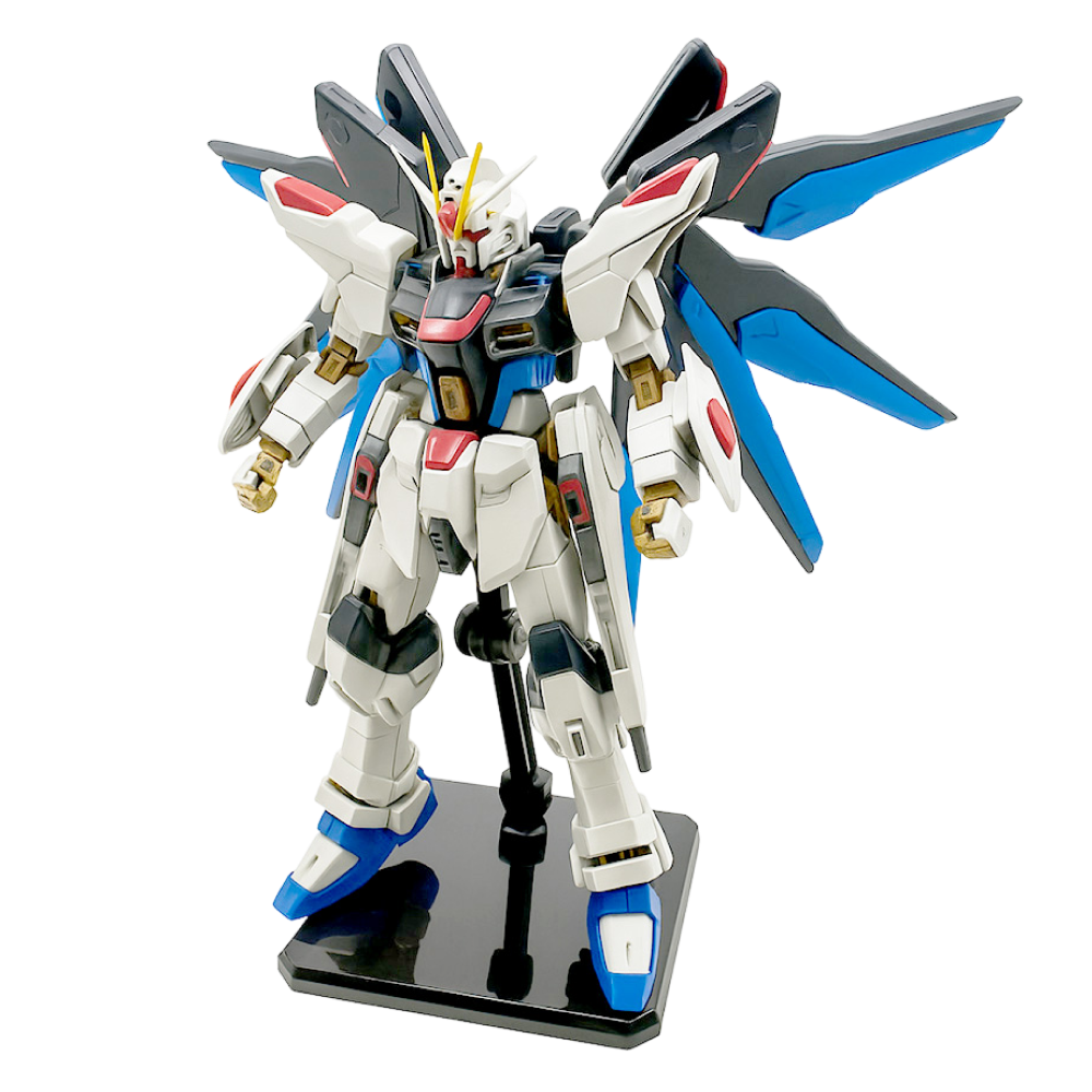 Gundam Strike Freedom Figure with blue wings, standing on a display base against a white background.