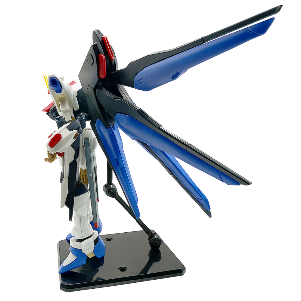 Side view of Gundam Strike Freedom Figure with extended blue and black wings on a display stand.