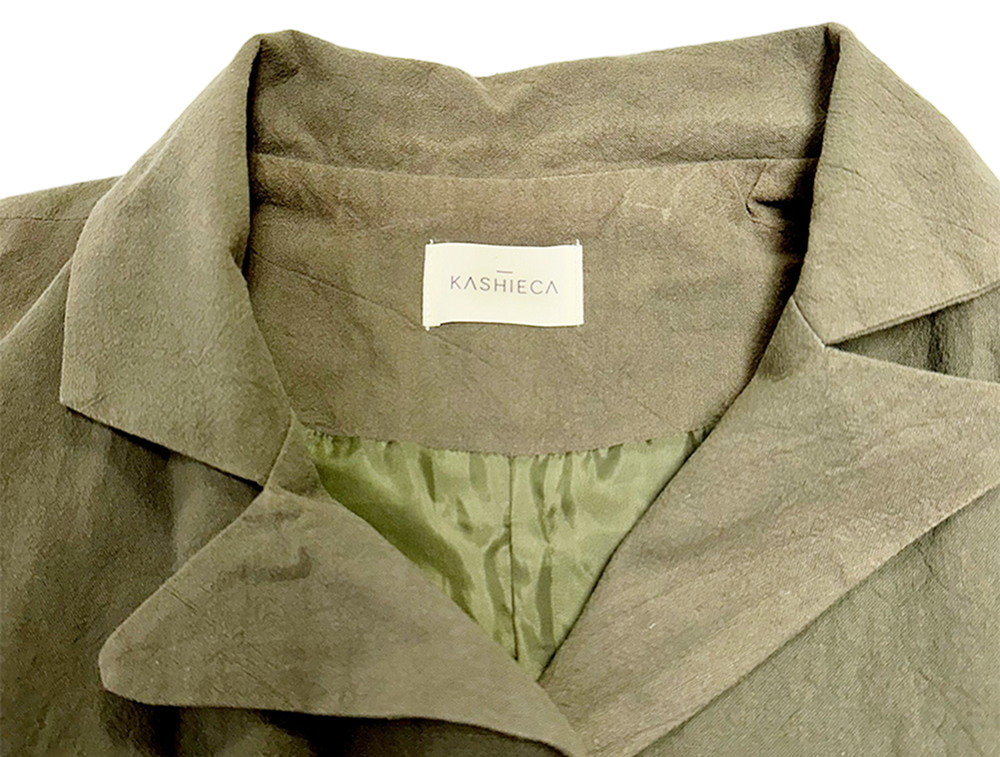 Close-up of the collar and label of a Kashieca olive green dress with an inner lining.