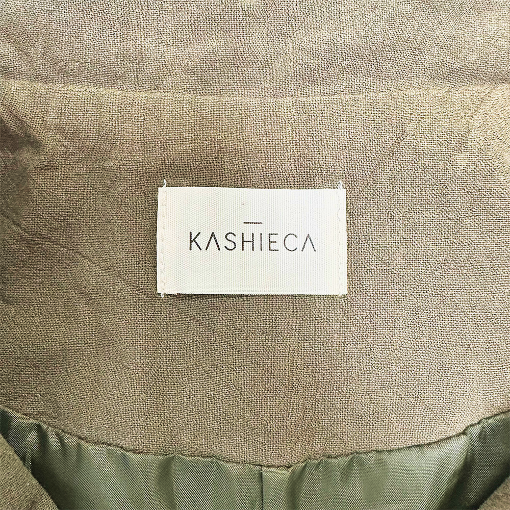Close-up of Kashieca label on an olive green dress fabric.