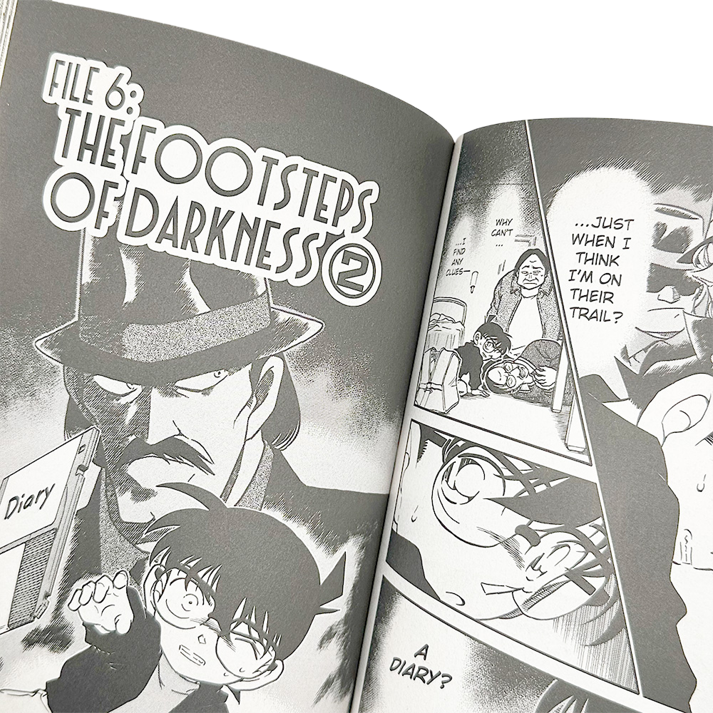 Detective Conan Volume 37 open to "The Footsteps of Darkness" with Conan examining a diary.