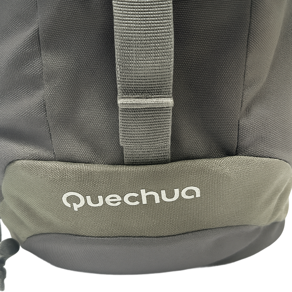 Close-up of the bottom corner of a Quechua Arpenaz Backpack showing the brand logo on grey fabric.