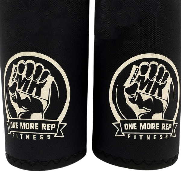 Close-up of One More Rep Fitness Kneepads featuring a fist logo and brand name on black fabric.