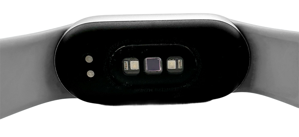 Close-up view of the Xiaomi Smart Band 9’s back sensors and charging connectors on the wristband.