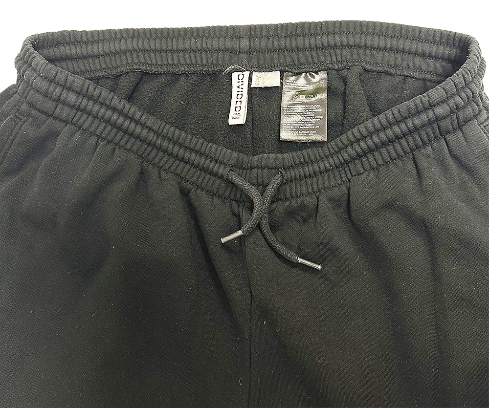 Close-up of H&M Women's Basic Sweatpants in black, featuring elastic waistband and drawstring.