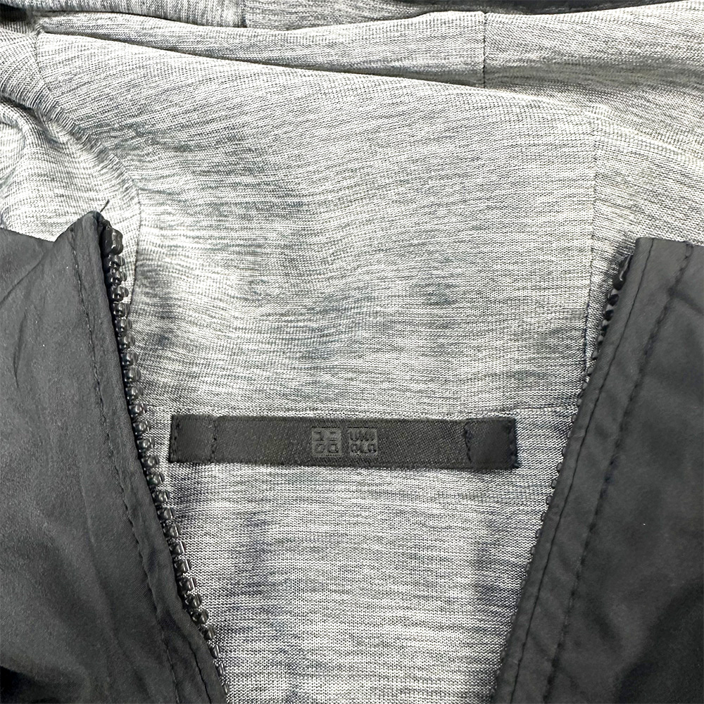 Close-up of Uniqlo Reversible Parka showing inner gray fabric and brand label near the neckline.