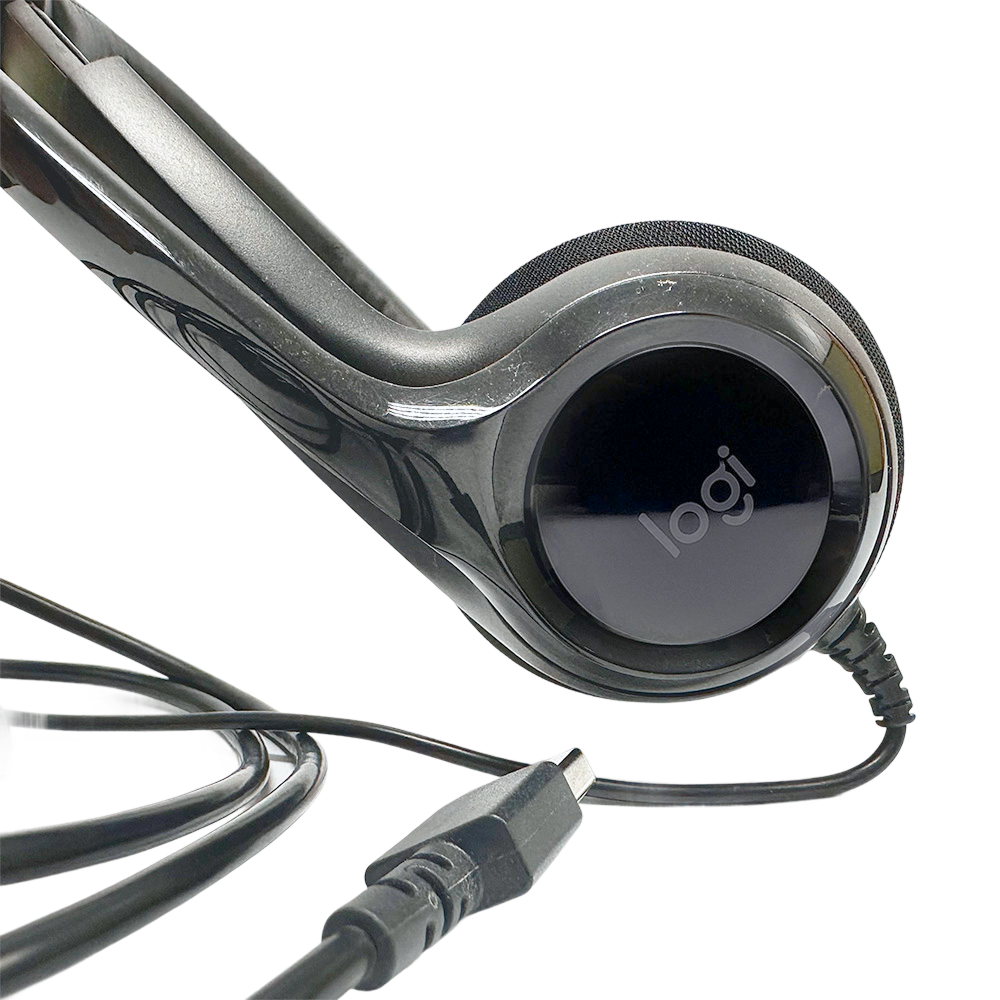 Close-up of Logitech H390 headset with mic and USB connector, featuring the Logi logo on the earcup.