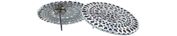 Pair of silver disc earrings with intricate cutout patterns displayed on a plain background.