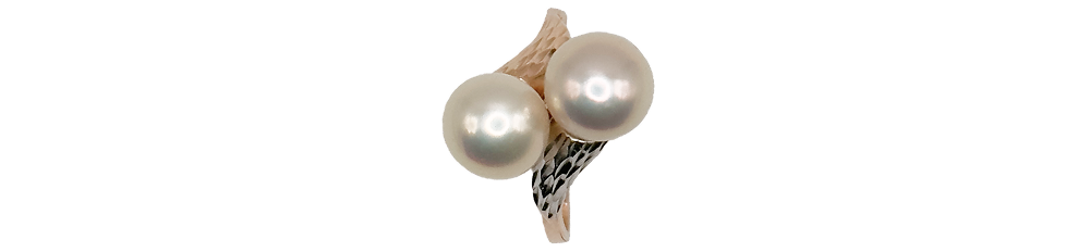 Gold-tone ring featuring two large, round pearls set on an intricate band.