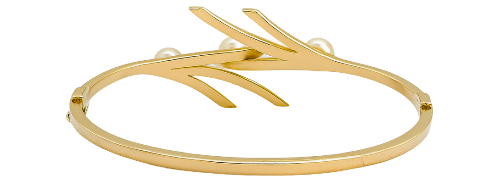Gold bangle bracelet with a modern, open design and pearl accents displayed on a white background.