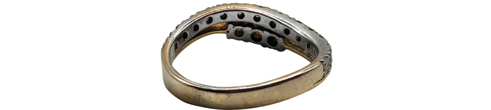 White gold diamond ring with a unique wave design, shown from the side highlighting band details.