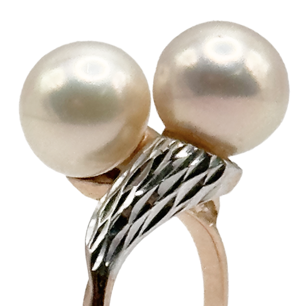 Gold-tone ring featuring two large, round pearls with a twisted, textured band.