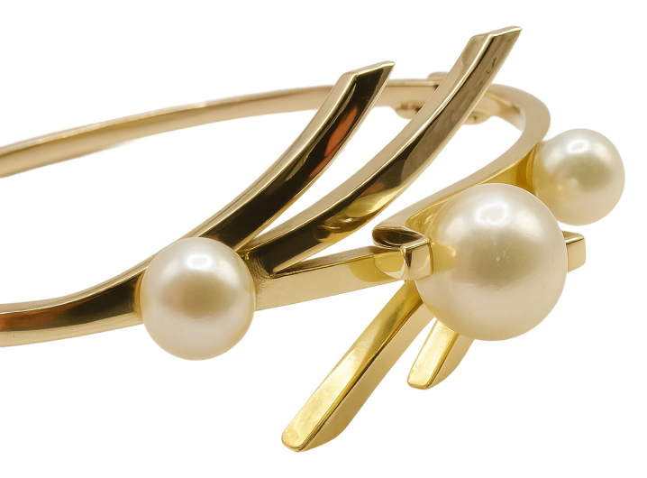 Gold bangle bracelet featuring three round white pearls and a modern, artistic design.