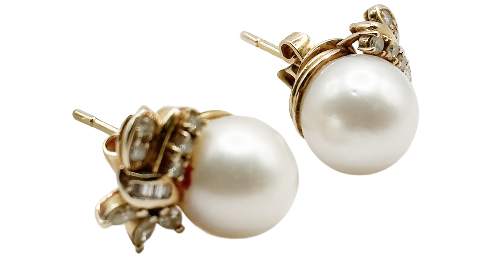 Pair of pearl stud earrings set in gold with decorative accents, displayed on a white background.