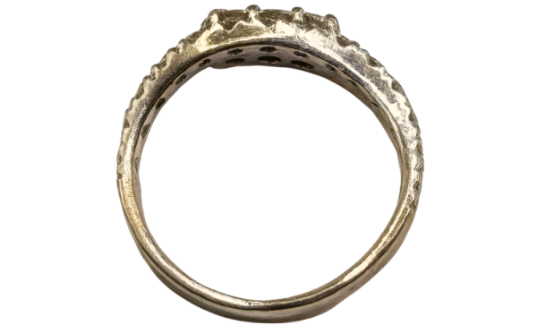 White gold diamond ring viewed from the side, showcasing band details and gemstone setting.