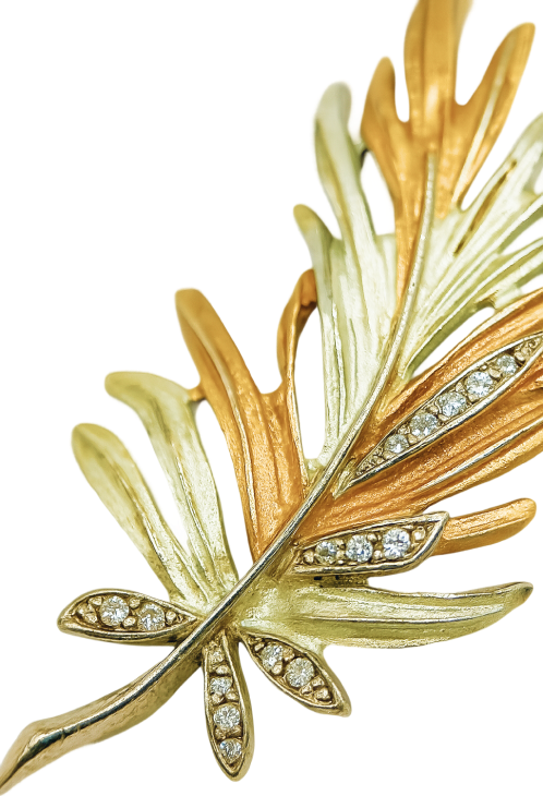 Two-tone gold leaf brooch with diamond accents, keyword 1, elegant accessory for formal occasions.