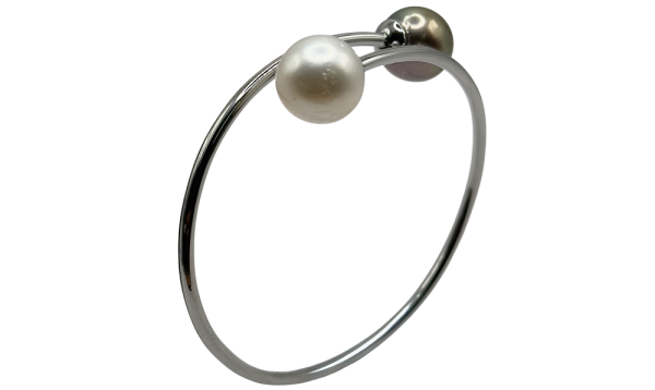 Silver bangle featuring one white pearl and one black pearl on each end.