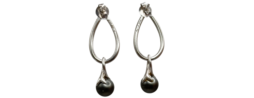 Pair of elegant silver drop earrings with teardrop-shaped hoops and dark round gemstone pendants.
