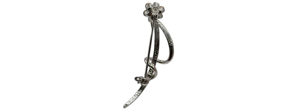 Silver-tone floral crystal brooch with curved stem and clear gemstone accents.
