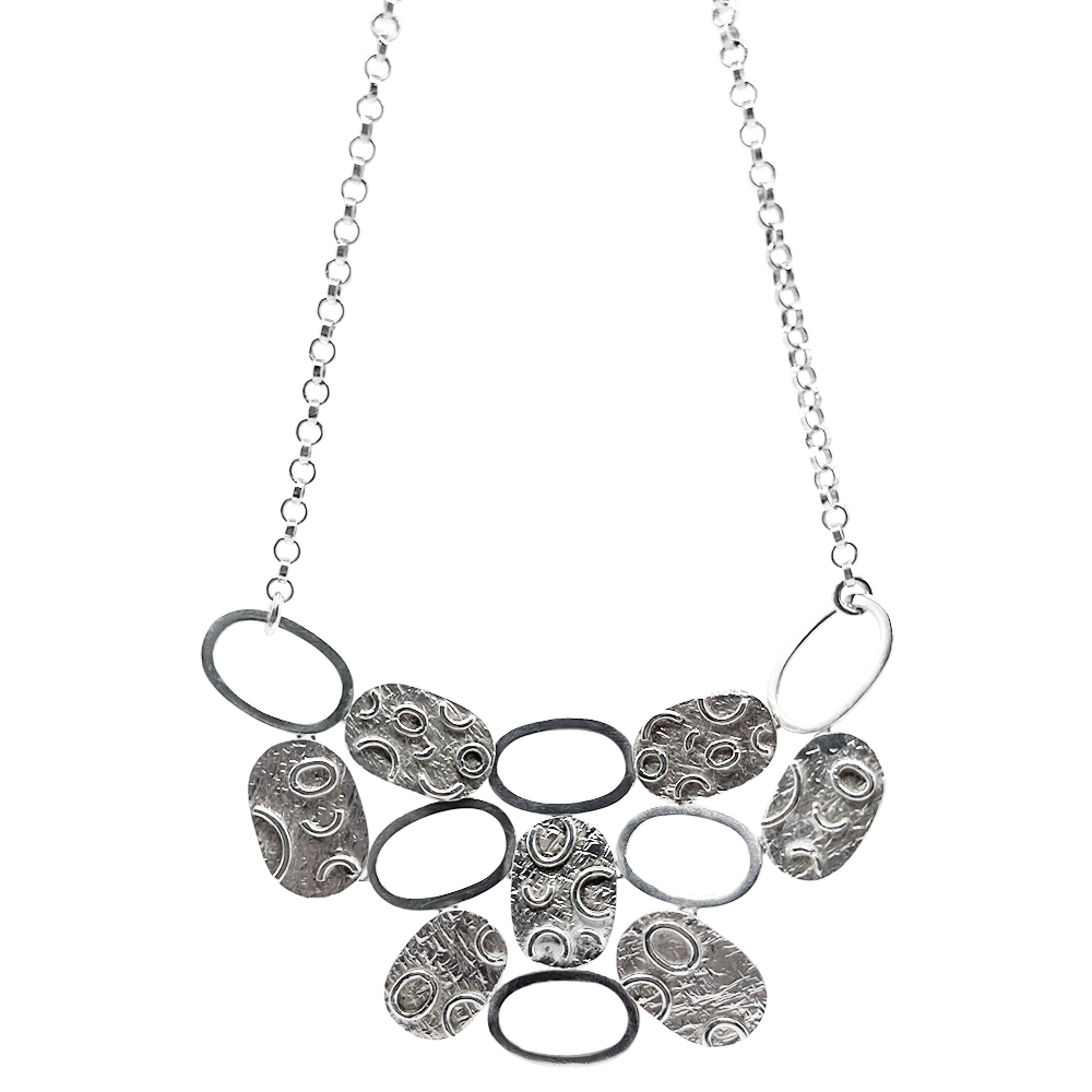 Silver disc necklace with textured circular and oval charms on a matching silver chain.