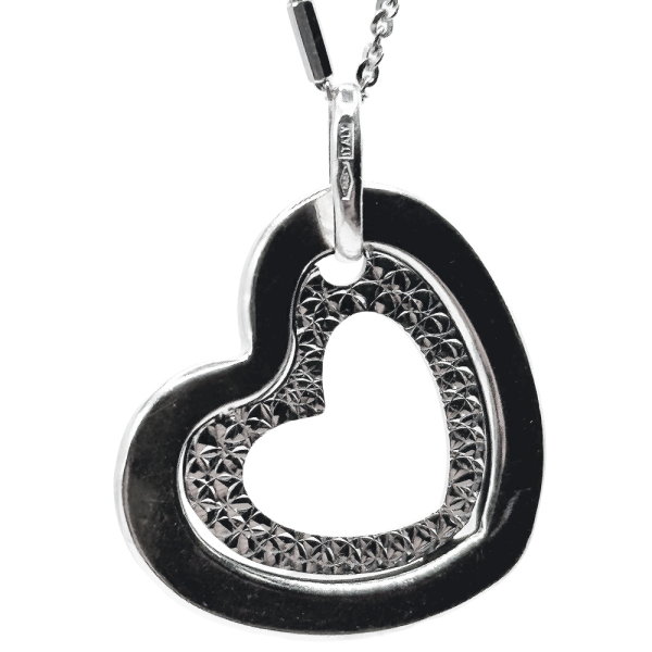 Silver heart pendant necklace with textured inner detailing, hanging from a delicate chain.